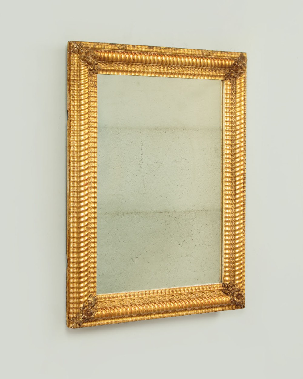 A small rectangular 19th-century French giltwood mirror with textured frame moulding and carved corner rosettes. View II