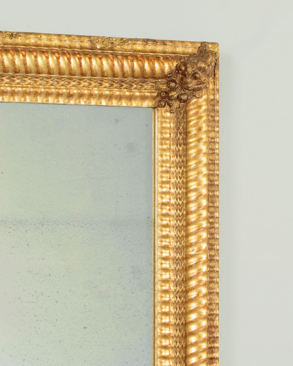 A small rectangular 19th-century French giltwood mirror with textured frame moulding and carved corner rosettes. View III
