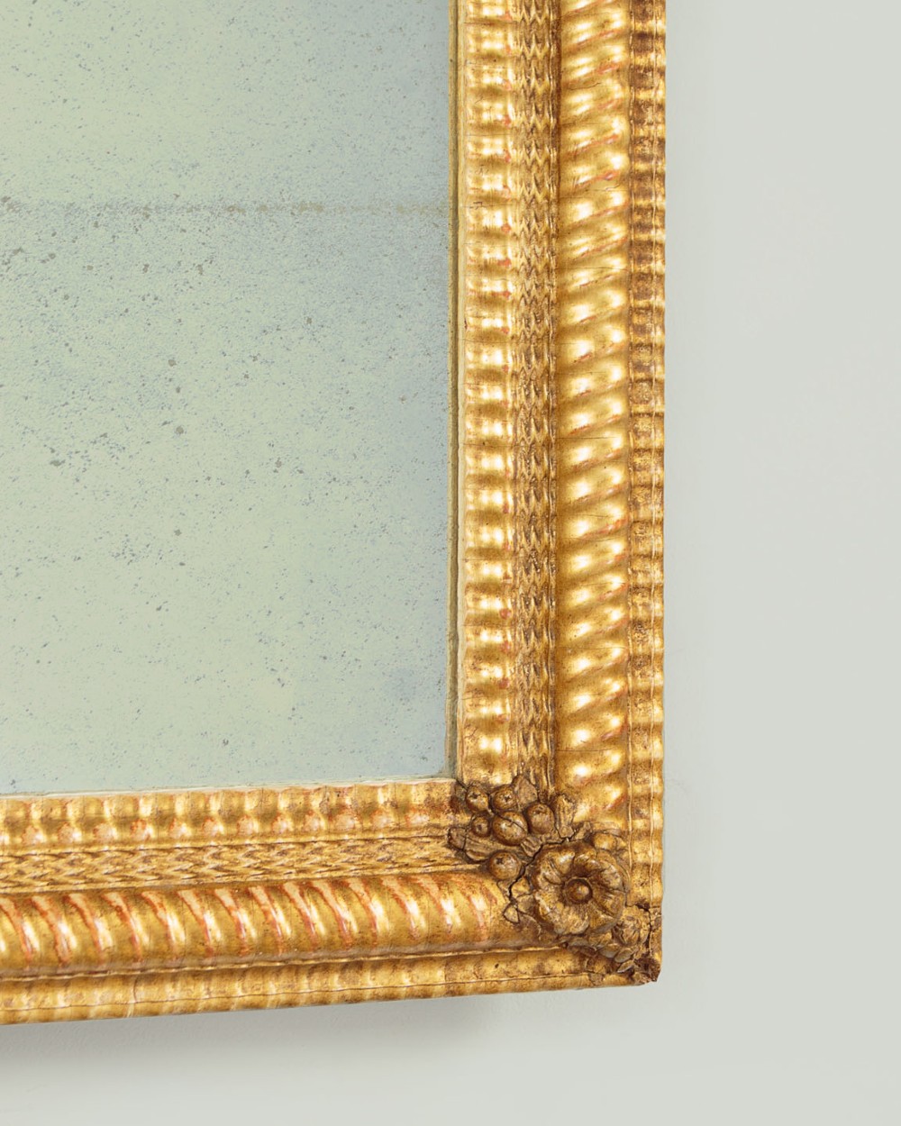 A small rectangular 19th-century French giltwood mirror with textured frame moulding and carved corner rosettes. View VI