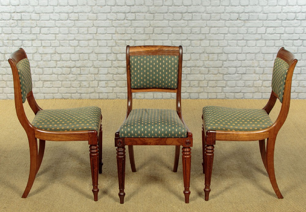 Set of six late Regency rosewood dining chairs featuring reeded front legs, sabre rear legs, and green patterned fabric upholstered seats and back panels. View II