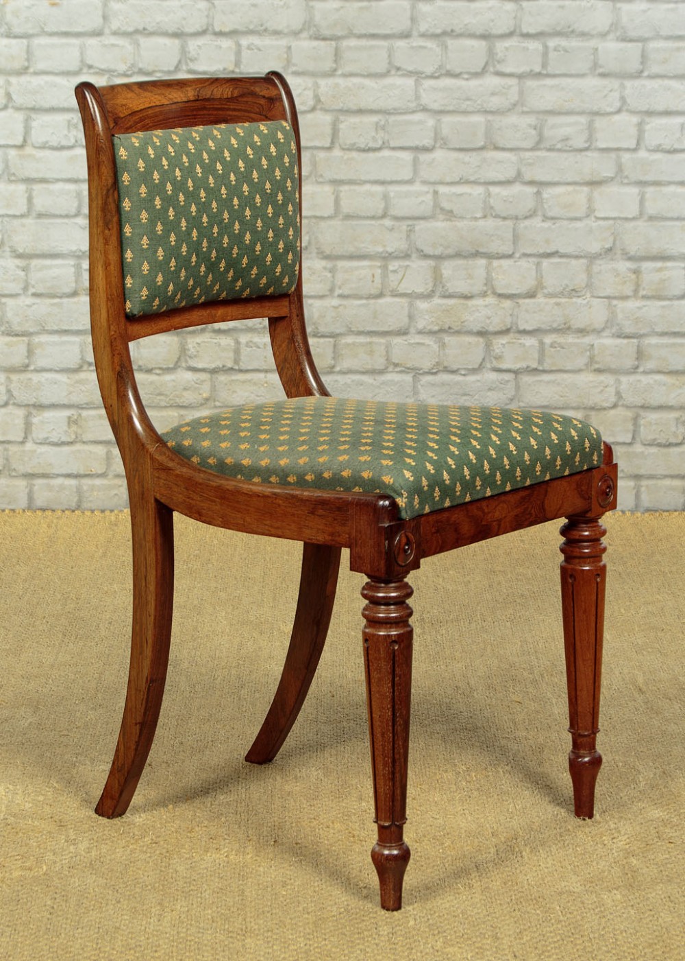 Set of six late Regency rosewood dining chairs featuring reeded front legs, sabre rear legs, and green patterned fabric upholstered seats and back panels. View III