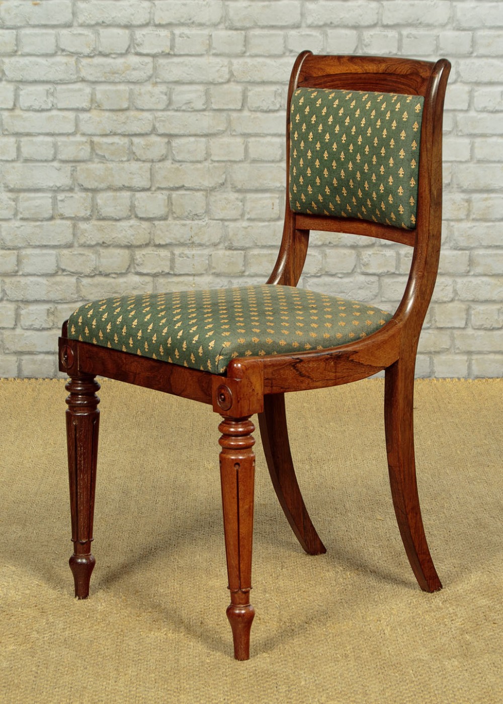Set of six late Regency rosewood dining chairs featuring reeded front legs, sabre rear legs, and green patterned fabric upholstered seats and back panels. View V