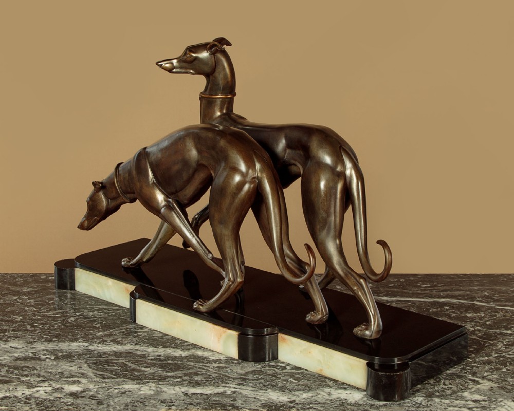 An Art Deco dark bronze sculpture featuring two sleek greyhounds poised on a stepped black marble and cream onyx base. View III