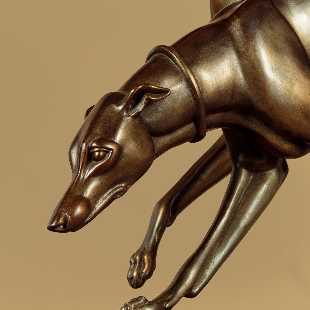 An Art Deco dark bronze sculpture featuring two sleek greyhounds poised on a stepped black marble and cream onyx base. View VI