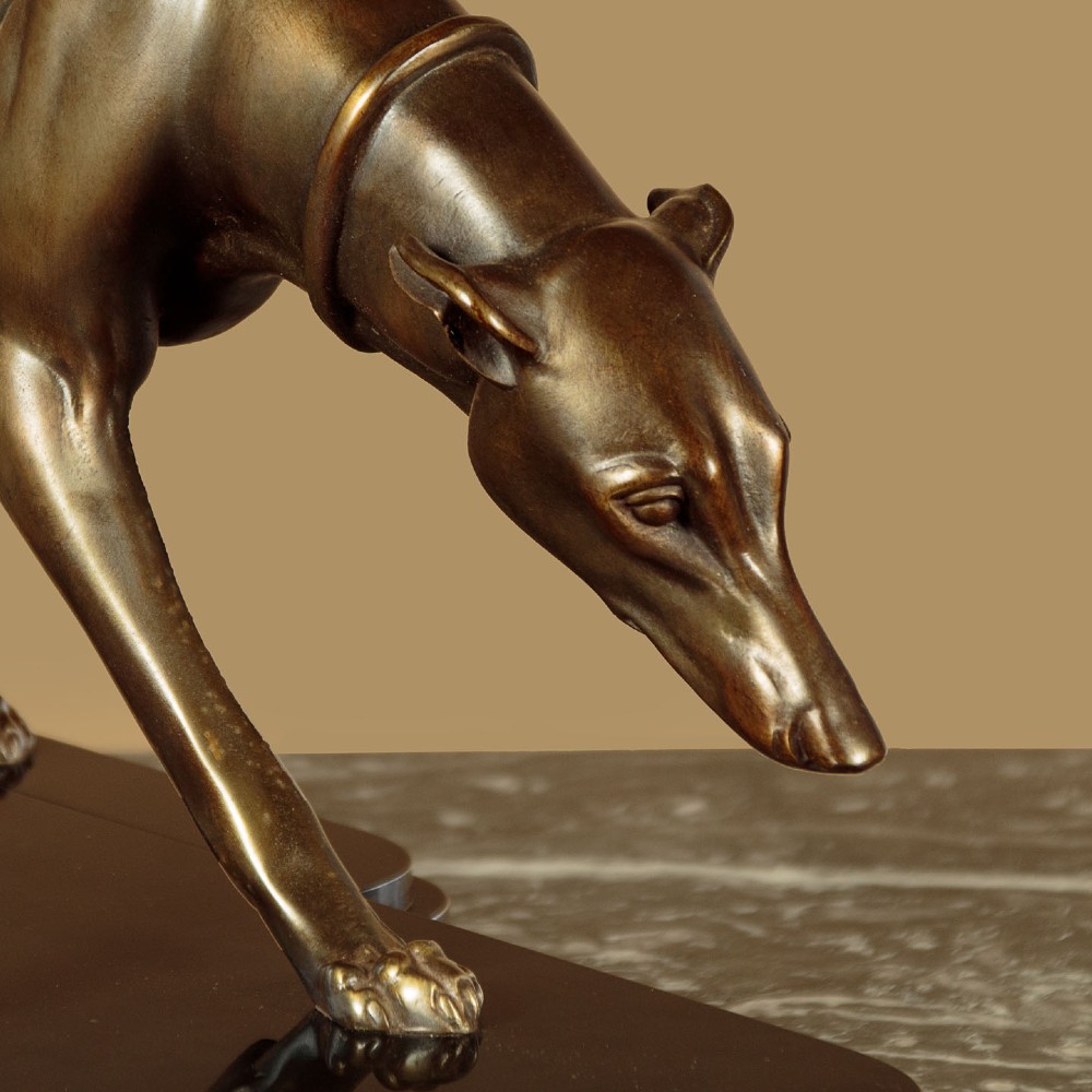 An Art Deco dark bronze sculpture featuring two sleek greyhounds poised on a stepped black marble and cream onyx base. View VII