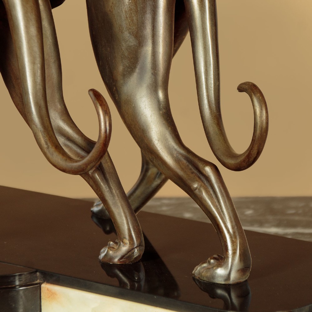 An Art Deco dark bronze sculpture featuring two sleek greyhounds poised on a stepped black marble and cream onyx base. View VIII