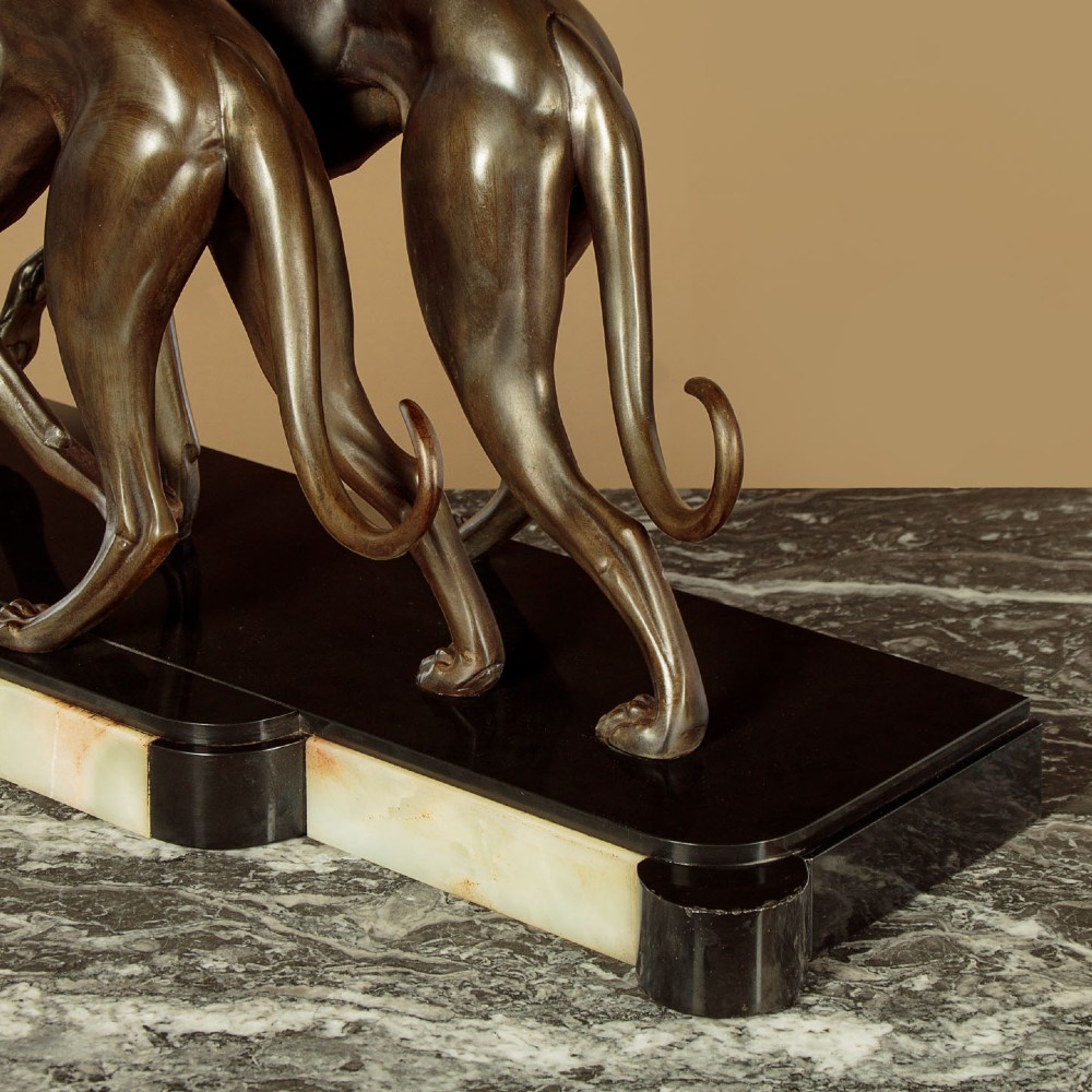 An Art Deco dark bronze sculpture featuring two sleek greyhounds poised on a stepped black marble and cream onyx base. View XI