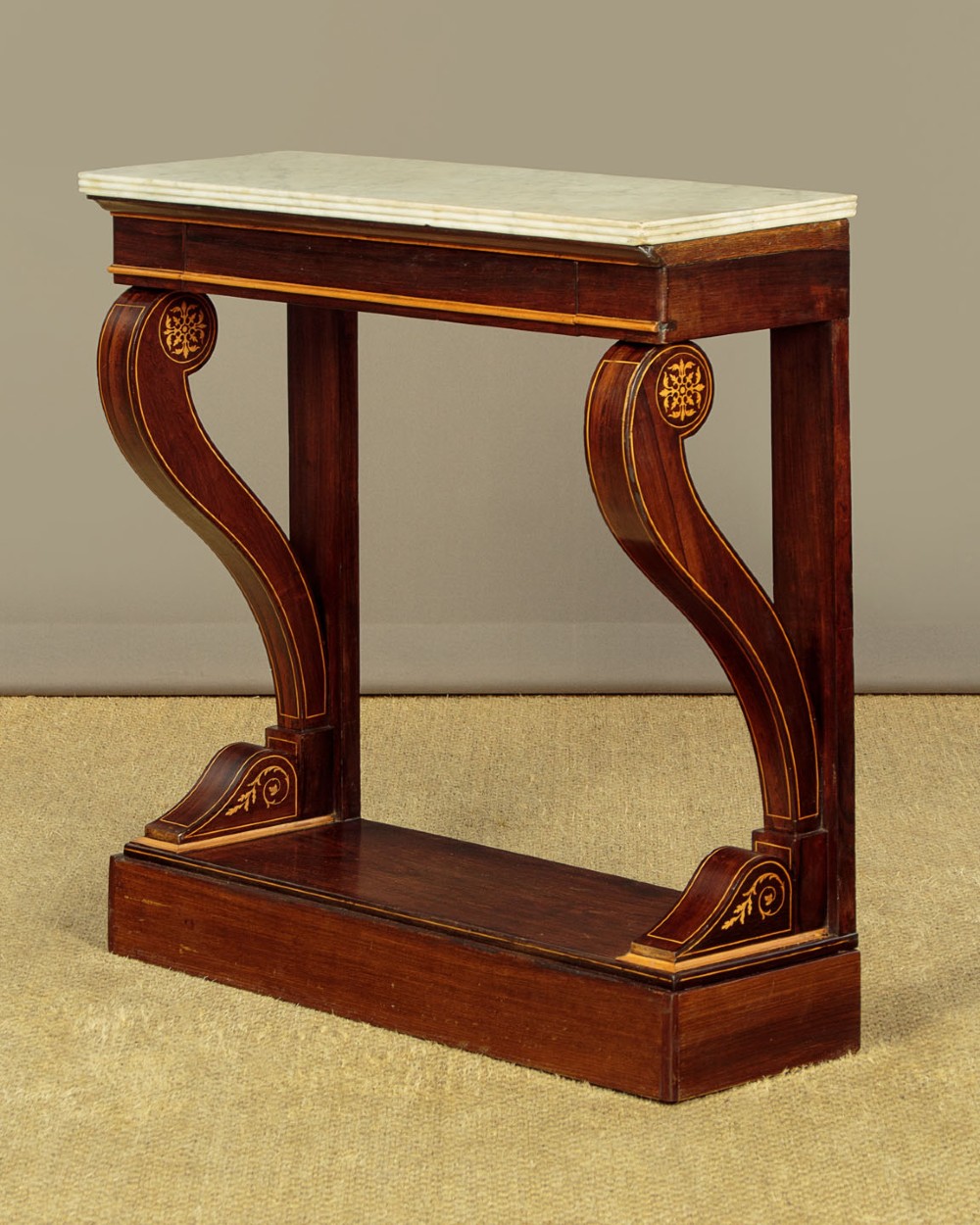 A small late Victorian mahogany console table featuring a white marble top, decorative marquetry on curved scroll legs, a single frieze drawer, and a solid plinth base. View III