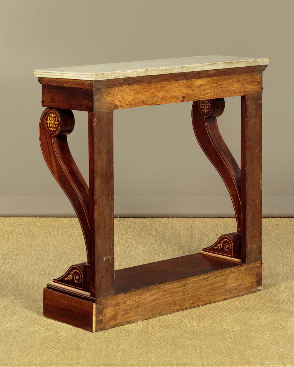 A small late Victorian mahogany console table featuring a white marble top, decorative marquetry on curved scroll legs, a single frieze drawer, and a solid plinth base. View X