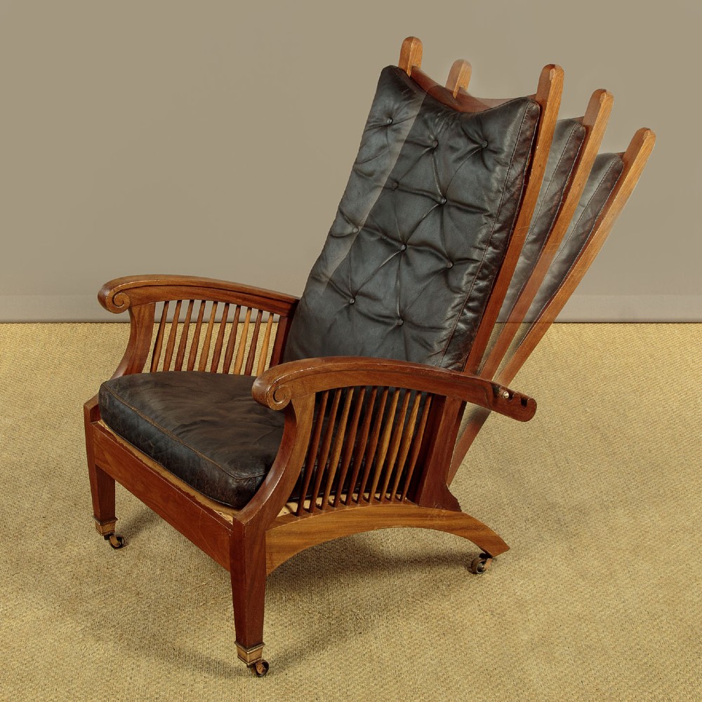 An Arts and Crafts adjustable reclining armchair in polished hardwood with slatted side panels and dark brown tufted leather cushions. View IV