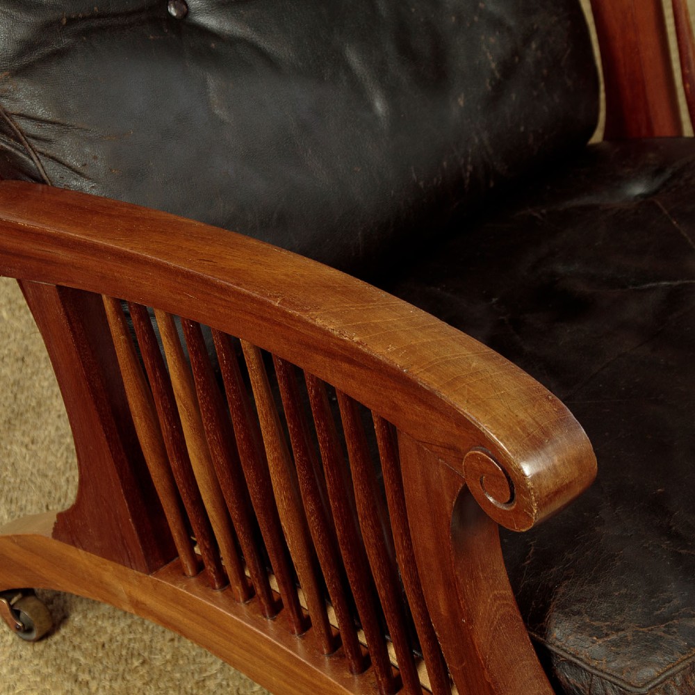 An Arts and Crafts adjustable reclining armchair in polished hardwood with slatted side panels and dark brown tufted leather cushions. View VII