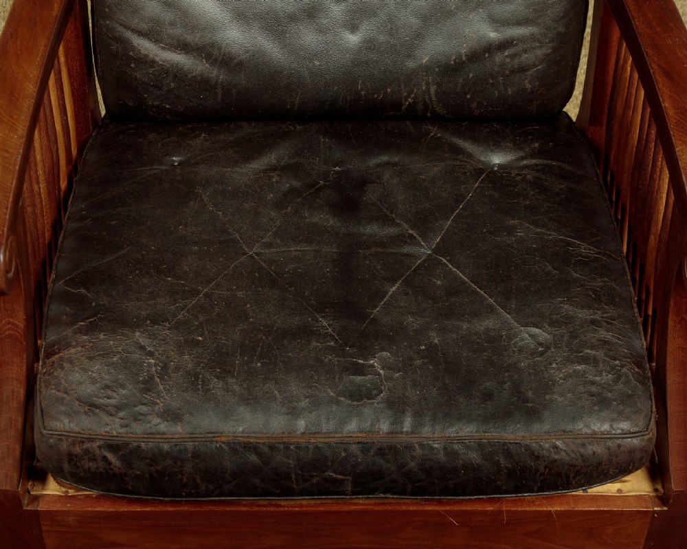 An Arts and Crafts adjustable reclining armchair in polished hardwood with slatted side panels and dark brown tufted leather cushions. View VIII