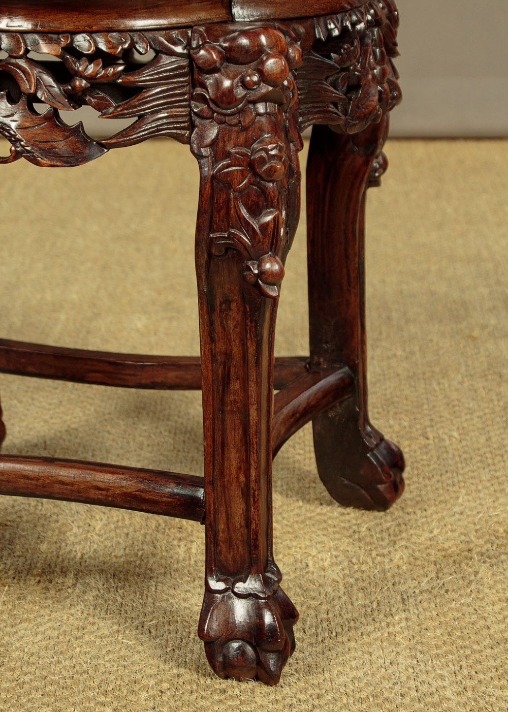 A low circular dark hardwood side table featuring an inset pink marble top, beaded rim, carved floral openwork apron, and claw feet. View IX