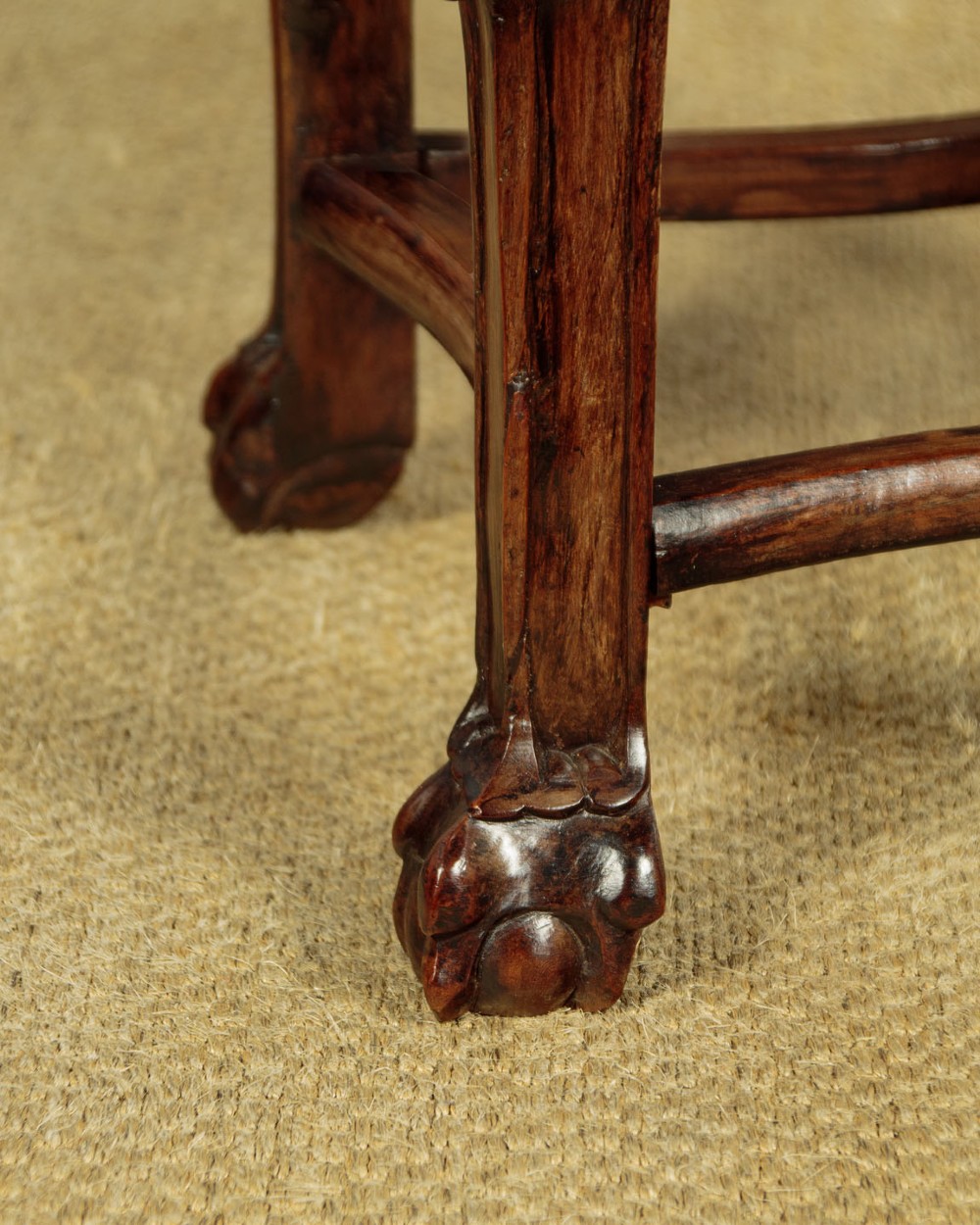 A low circular dark hardwood side table featuring an inset pink marble top, beaded rim, carved floral openwork apron, and claw feet. View X