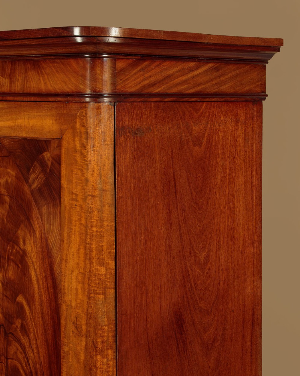 A mid-19th century compact Victorian mahogany wardrobe with flame mahogany arched door panels and round bun feet. View V