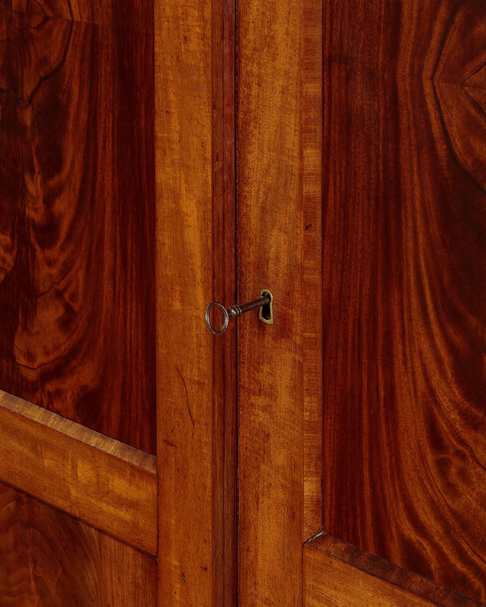 A mid-19th century compact Victorian mahogany wardrobe with flame mahogany arched door panels and round bun feet. View VII
