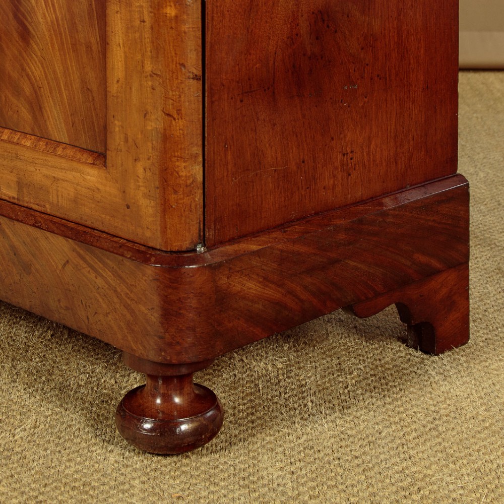 A mid-19th century compact Victorian mahogany wardrobe with flame mahogany arched door panels and round bun feet. View X