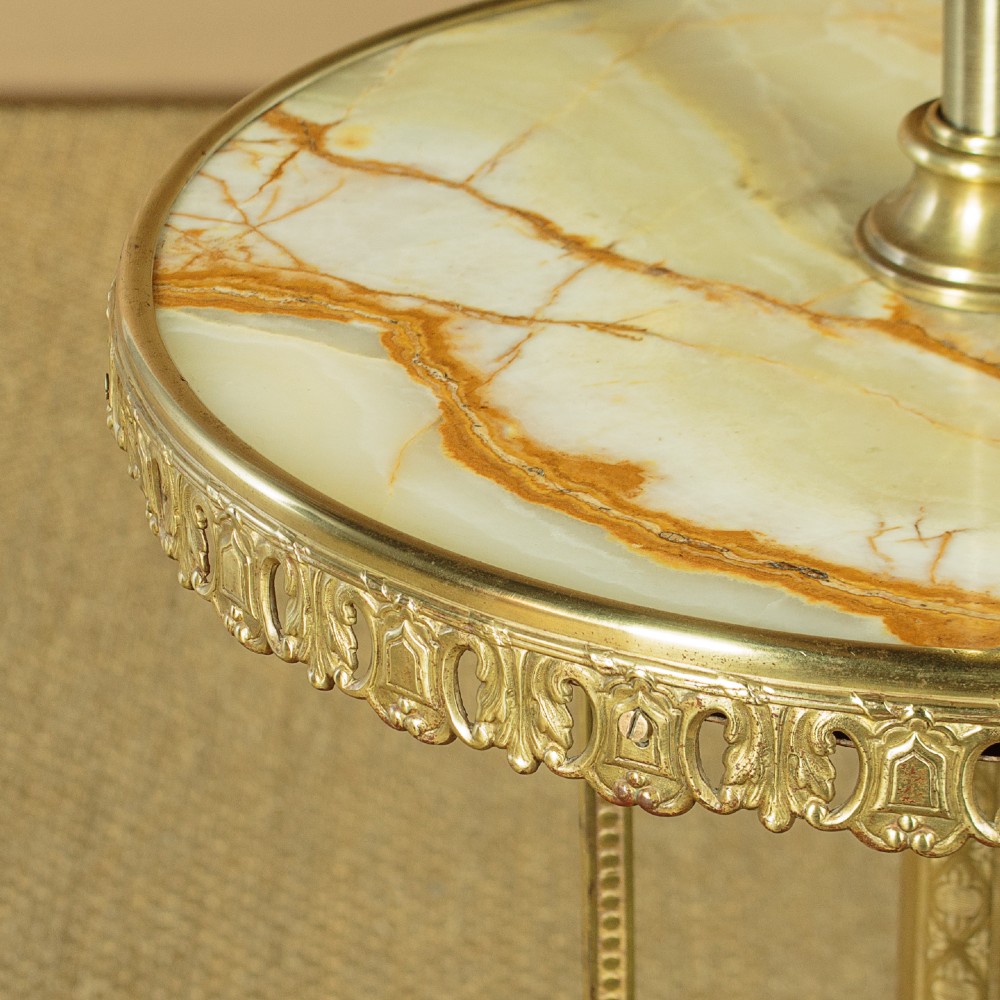 An Edwardian brass standard lamp featuring an integrated circular onyx wine table with a pierced gallery trim atop a scrolling tripod base. View VII