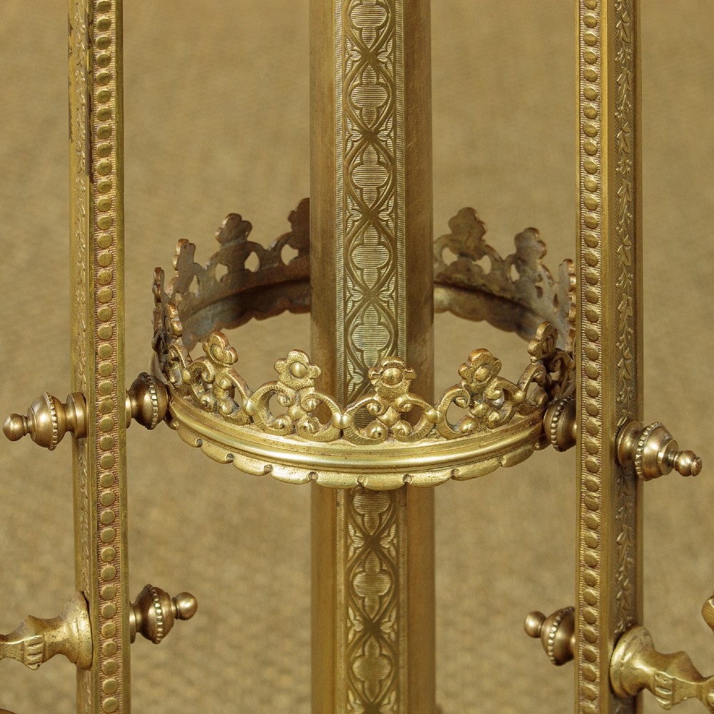 An Edwardian brass standard lamp featuring an integrated circular onyx wine table with a pierced gallery trim atop a scrolling tripod base. View IX