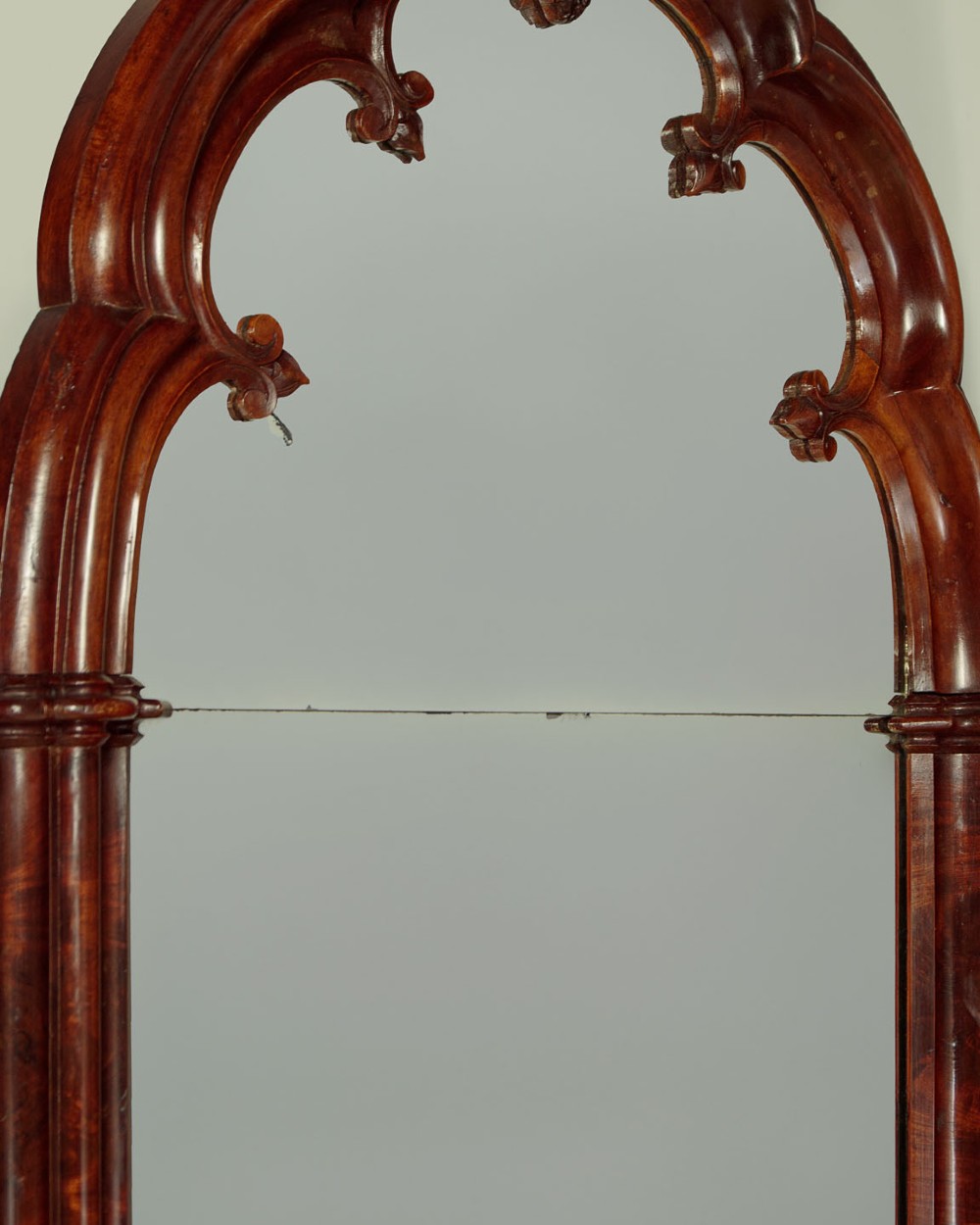 A tall and narrow 19th-century dark mahogany pier mirror featuring a carved Gothic arch cresting and moulded side pillars. View VI