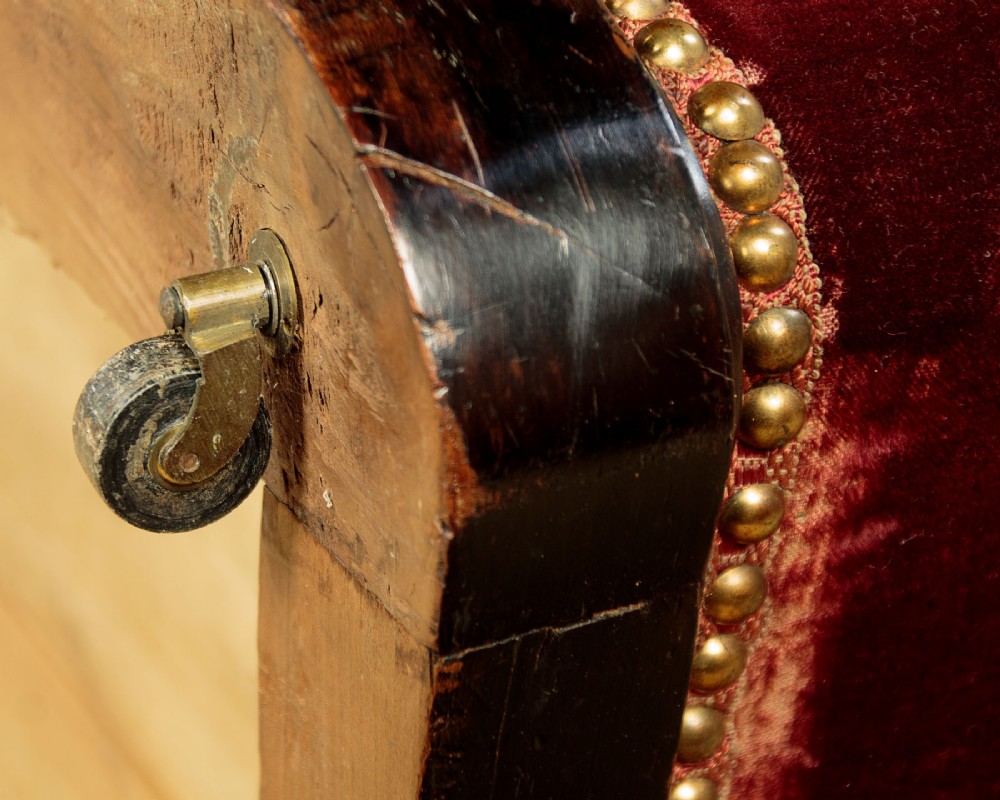 A late Victorian rectangular upholstered ottoman log box covered in deep burgundy velvet with two embroidered tapestry bands and brass stud trim, set on a dark wooden curved base. View XIV