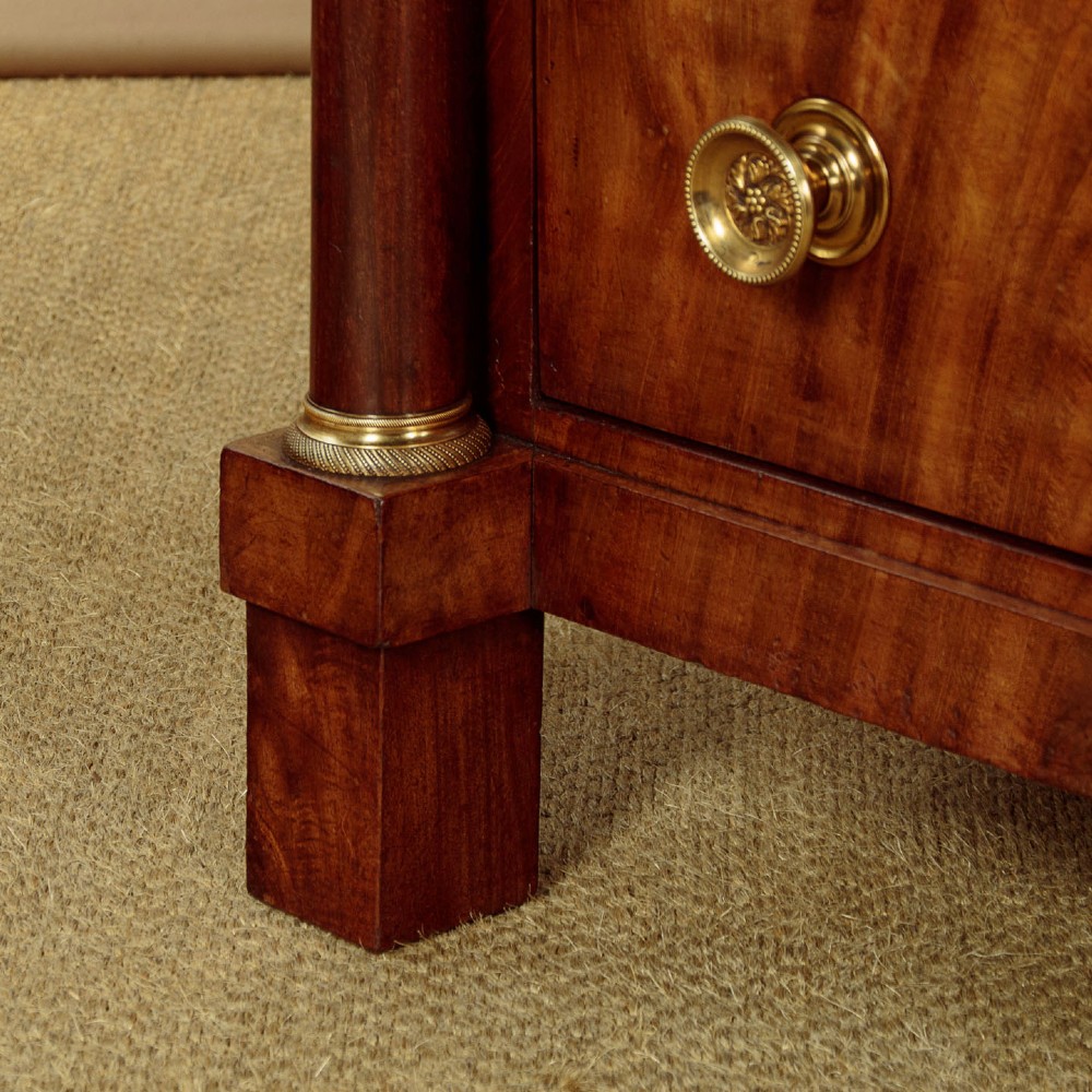 A small 19th-century Empire style mahogany chest featuring four drawers with flame veneer finishes, brass knob handles, keyhole escutcheons, and flank columns. View XIV