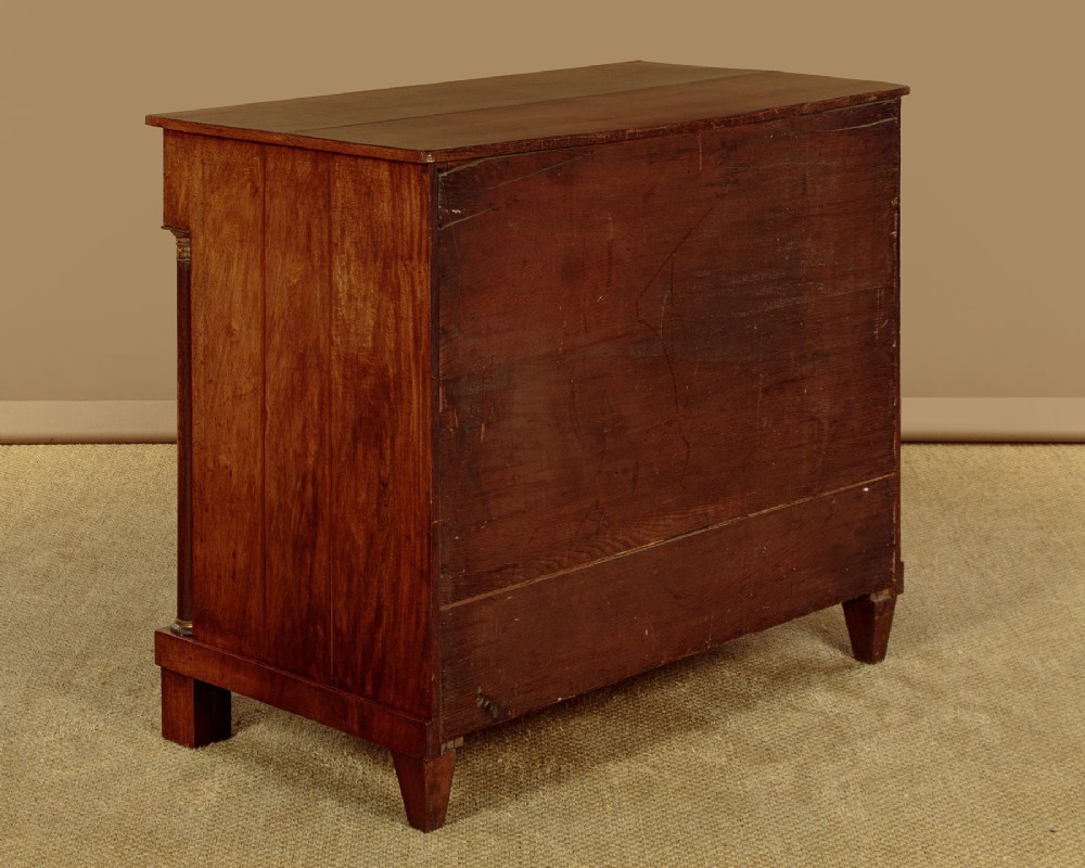 A small 19th-century Empire style mahogany chest featuring four drawers with flame veneer finishes, brass knob handles, keyhole escutcheons, and flank columns. View XV