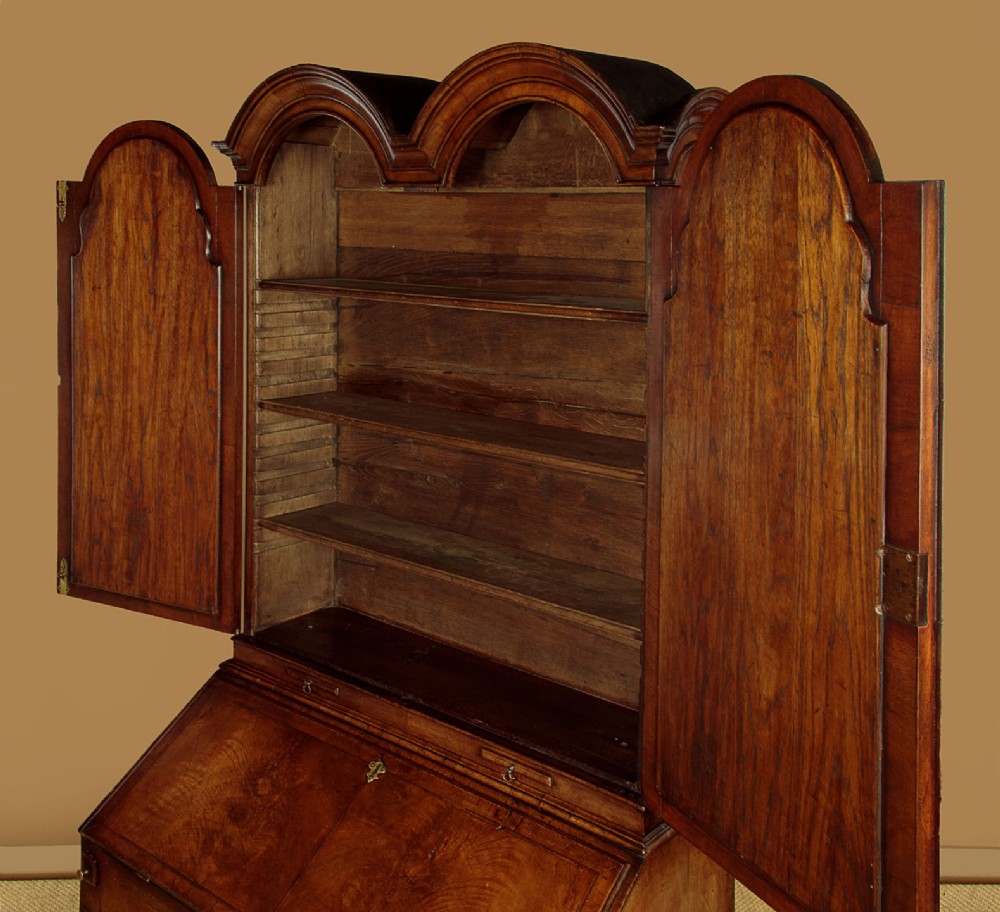 A Queen Anne style burr walnut bureau cabinet featuring a double-domed top with twin mirrored doors above a slant-front writing slope and lower drawers. View VI