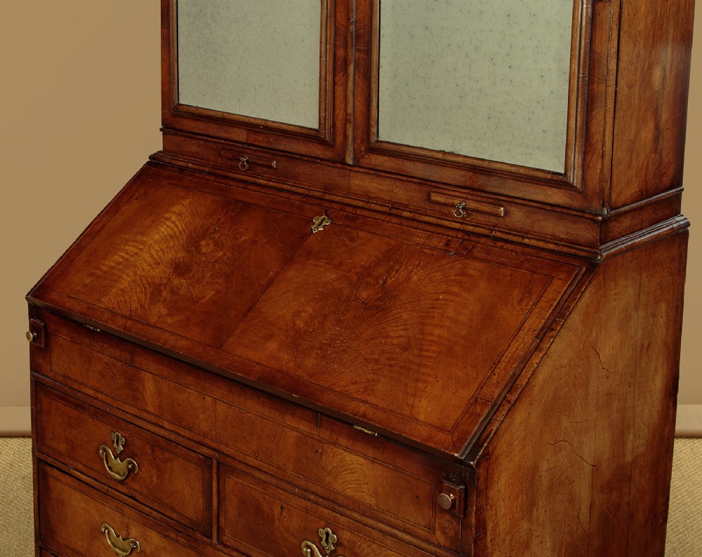 A Queen Anne style burr walnut bureau cabinet featuring a double-domed top with twin mirrored doors above a slant-front writing slope and lower drawers. View VIII