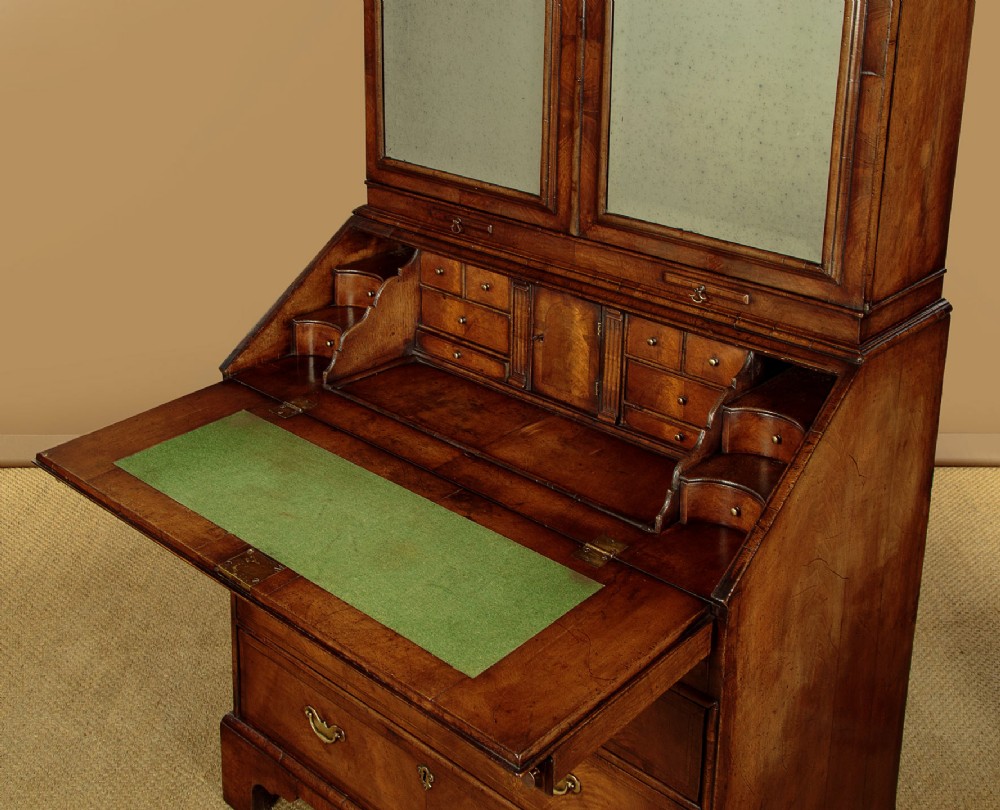A Queen Anne style burr walnut bureau cabinet featuring a double-domed top with twin mirrored doors above a slant-front writing slope and lower drawers. View IX