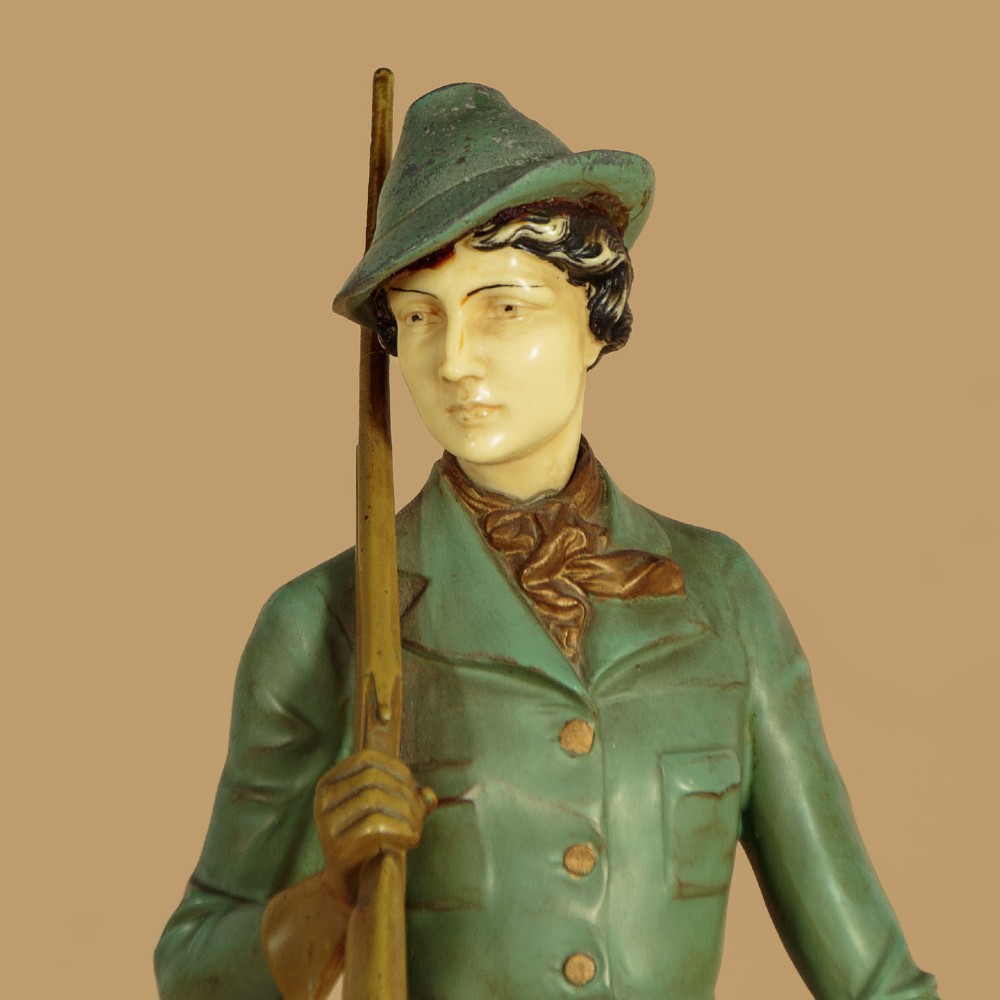 Art Deco figure group depicting a huntress in a green suit with two hunting dogs mounted on an oval marble base. View VI