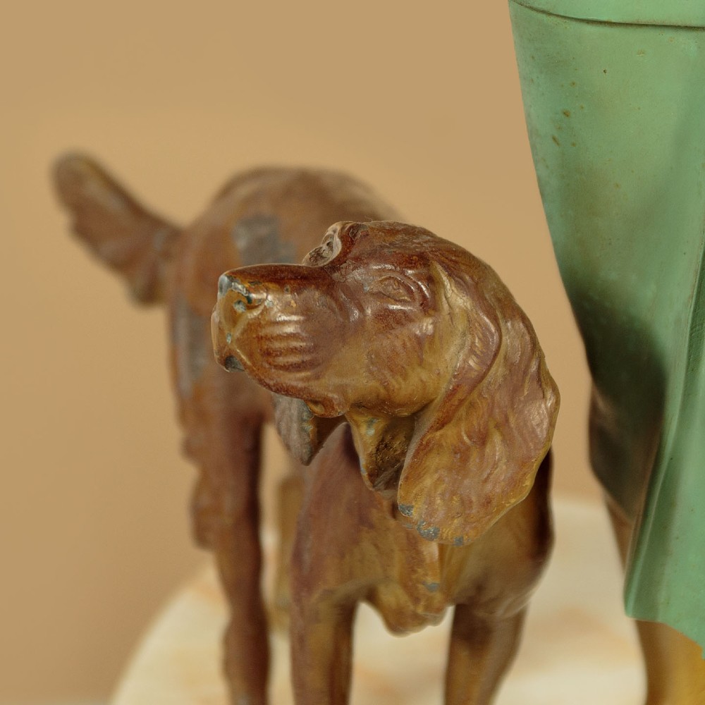 Art Deco figure group depicting a huntress in a green suit with two hunting dogs mounted on an oval marble base. View XII