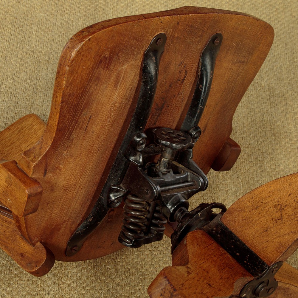 An early twentieth-century solid oak revolving desk chair featuring a slatted backrest, curved armrests, and a quadruped base on castors. View XII