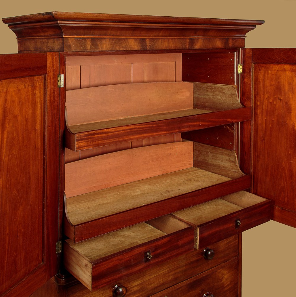 A mid-19th century mahogany linen press featuring two arched panel doors over three full-width drawers with turned wooden handles. View VI