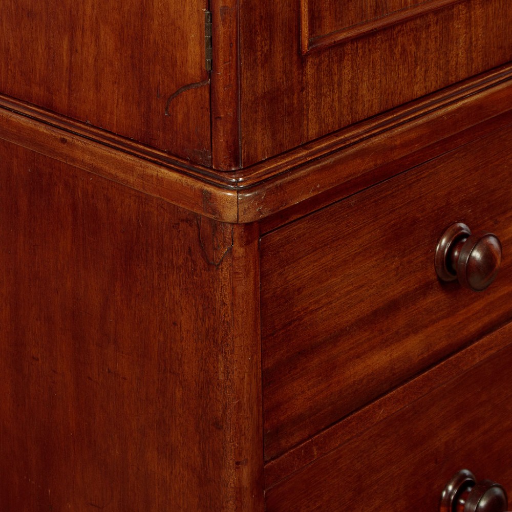 A mid-19th century mahogany linen press featuring two arched panel doors over three full-width drawers with turned wooden handles. View VIII