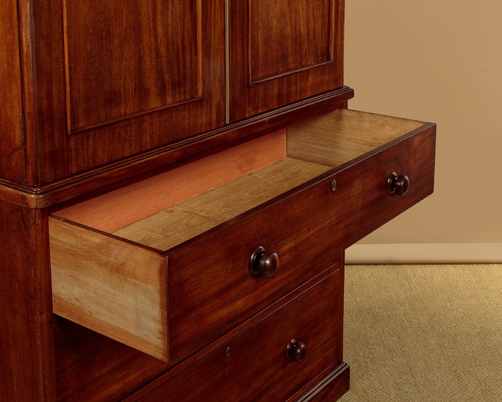 A mid-19th century mahogany linen press featuring two arched panel doors over three full-width drawers with turned wooden handles. View XI