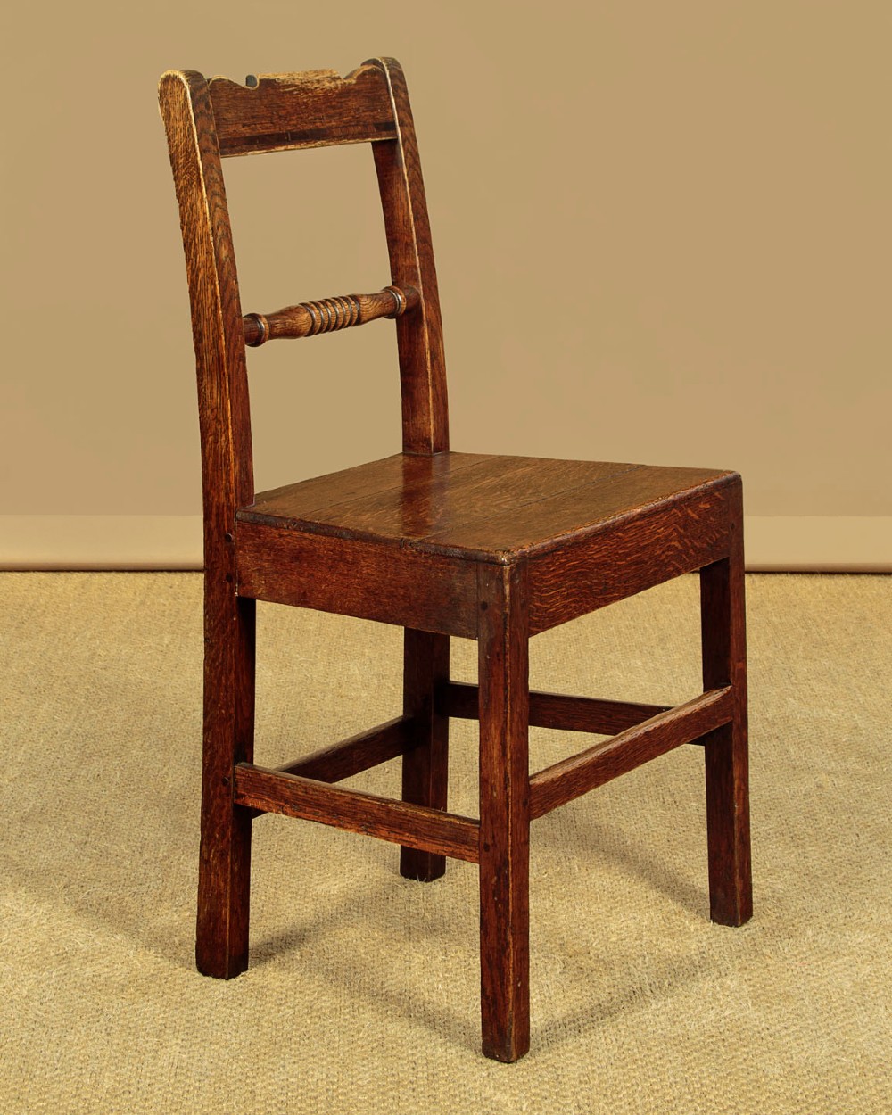 A set of four mid-19th-century Welsh oak cottage dining chairs with solid timber seats, turned centre spindles, and square stretchers. View III