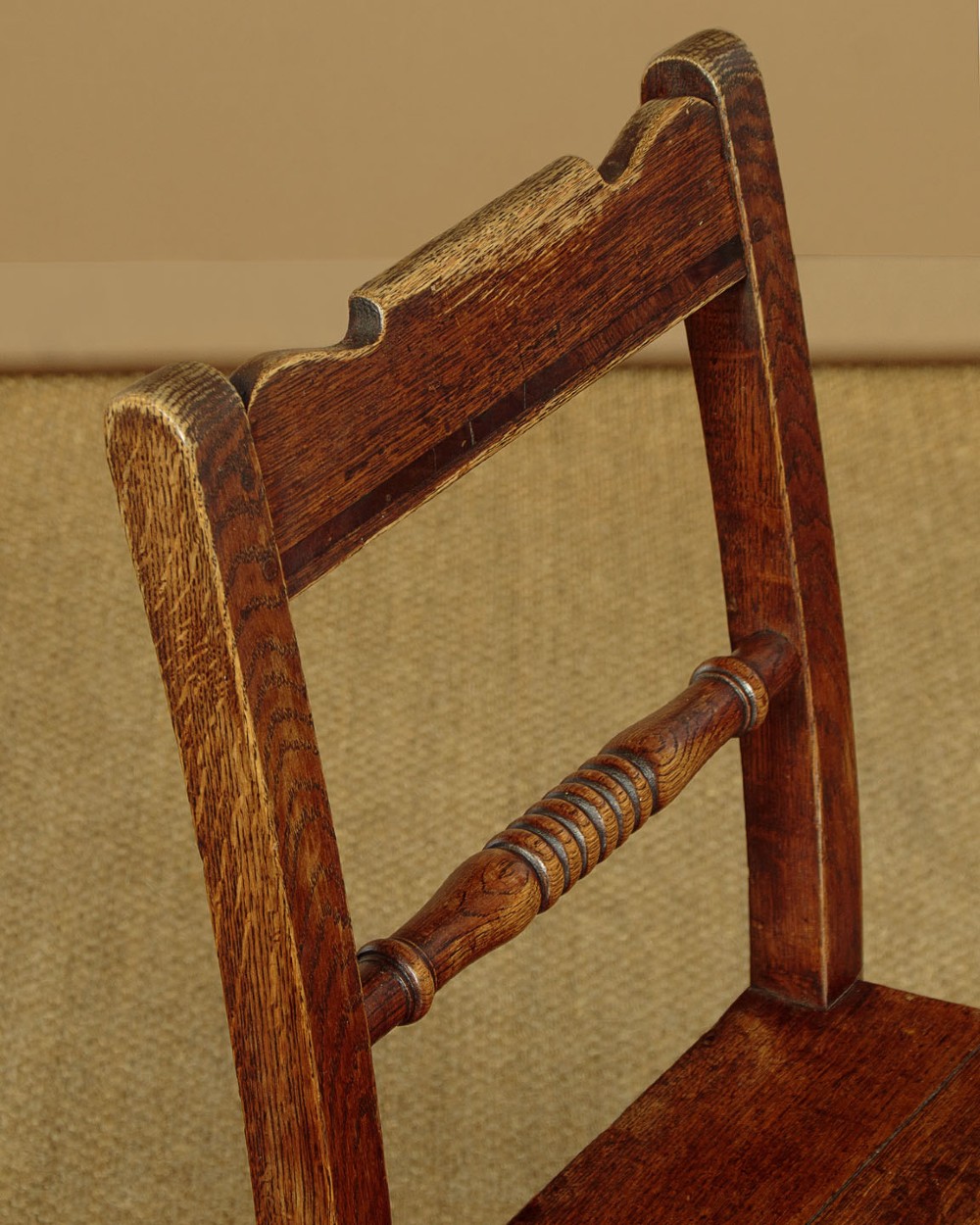 A set of four mid-19th-century Welsh oak cottage dining chairs with solid timber seats, turned centre spindles, and square stretchers. View VI