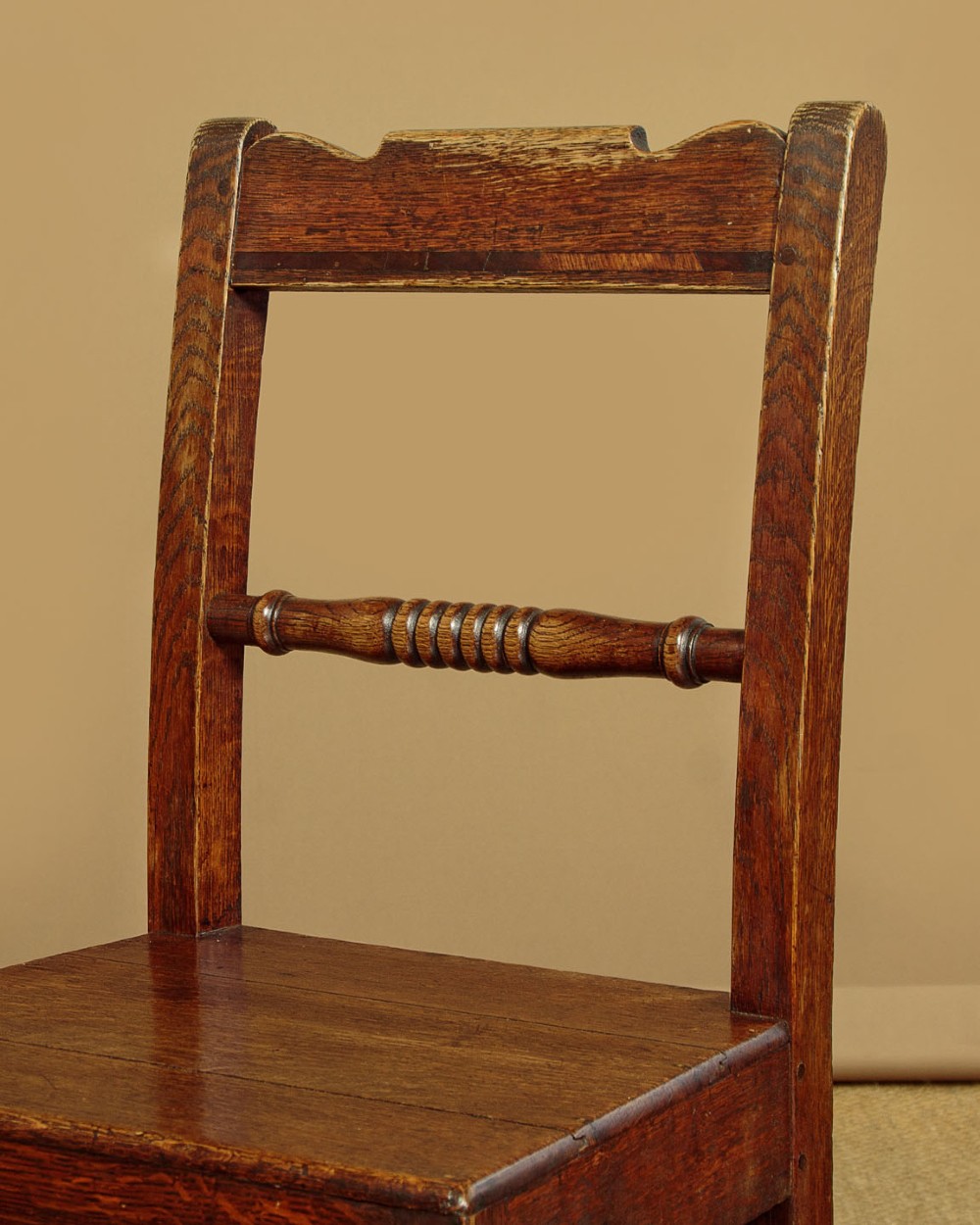 A set of four mid-19th-century Welsh oak cottage dining chairs with solid timber seats, turned centre spindles, and square stretchers. View VII