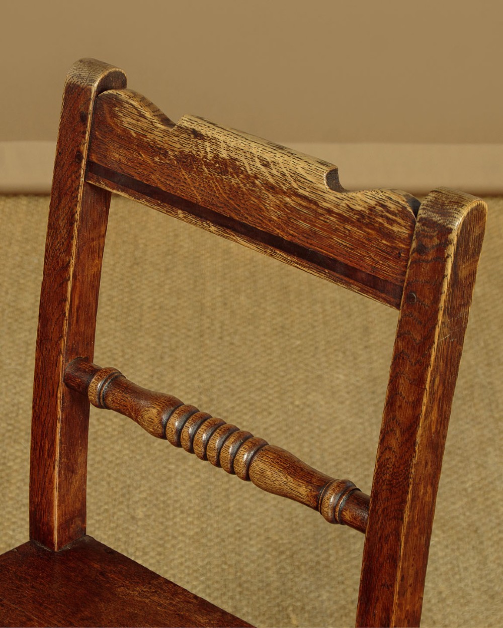 A set of four mid-19th-century Welsh oak cottage dining chairs with solid timber seats, turned centre spindles, and square stretchers. View VIII
