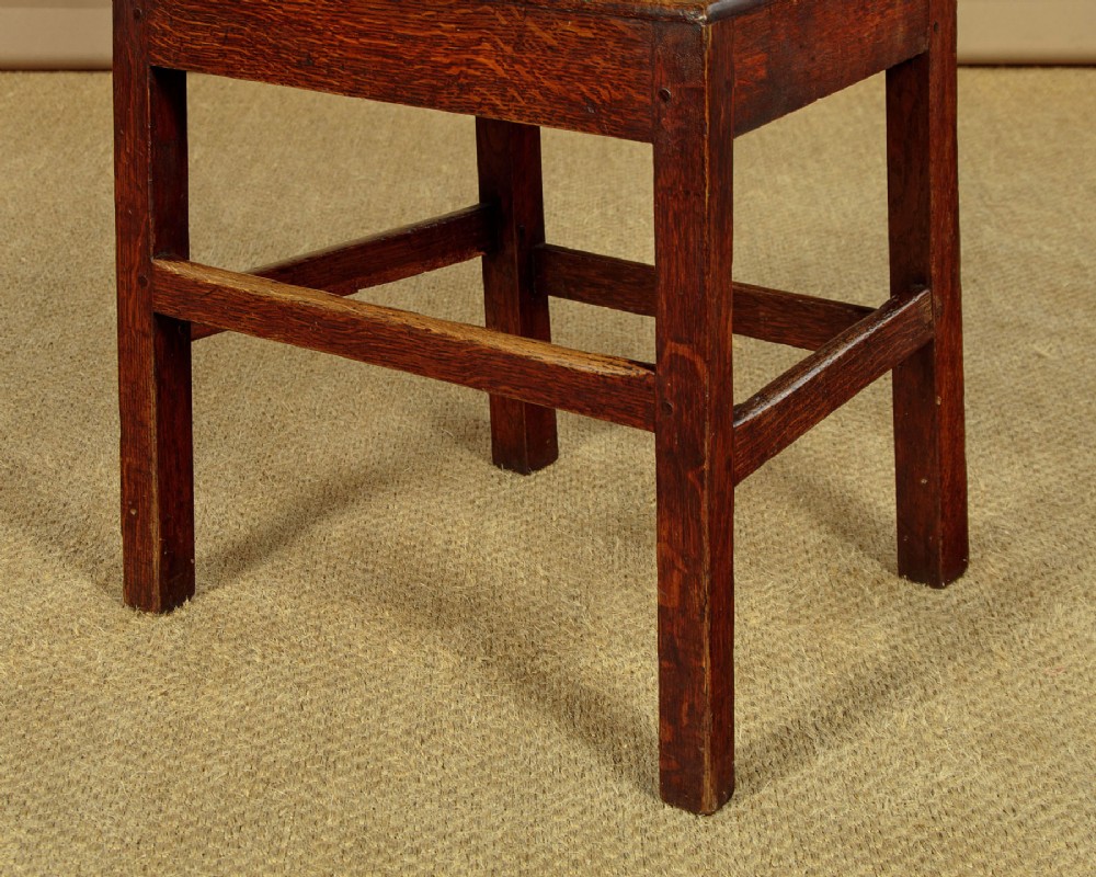 A set of four mid-19th-century Welsh oak cottage dining chairs with solid timber seats, turned centre spindles, and square stretchers. View XII