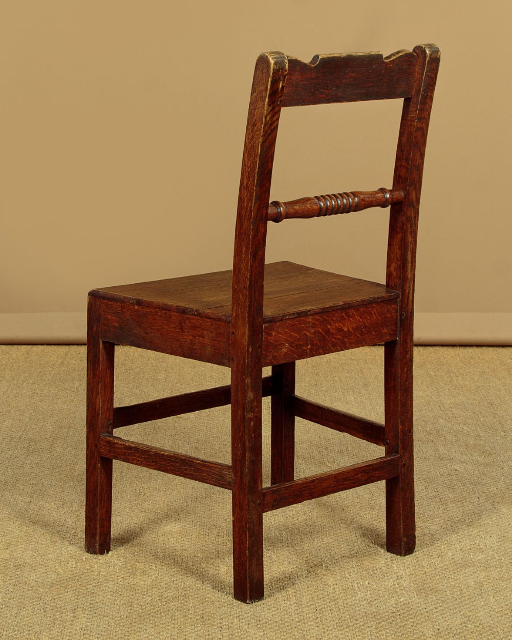 A set of four mid-19th-century Welsh oak cottage dining chairs with solid timber seats, turned centre spindles, and square stretchers. View XIII