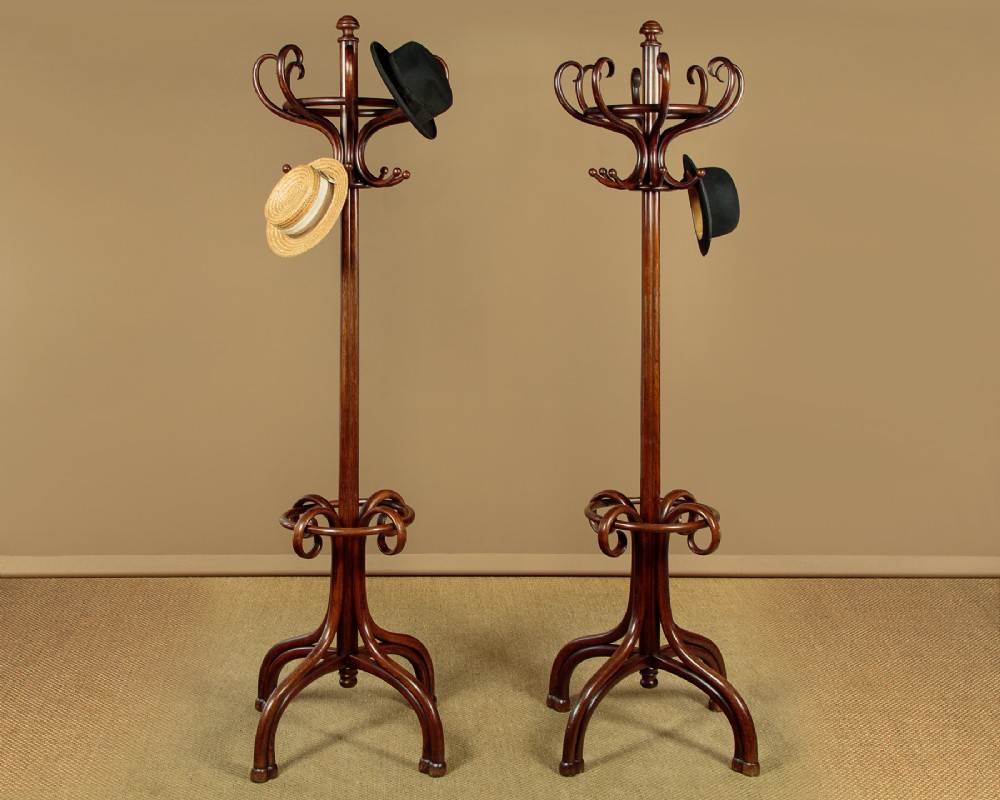 A pair of tall dark brown bentwood hallstands featuring curved coat hooks at the top and circular loops at the base for umbrellas. View II