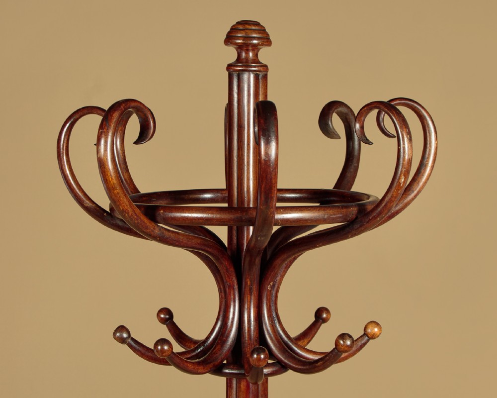 A pair of tall dark brown bentwood hallstands featuring curved coat hooks at the top and circular loops at the base for umbrellas. View V