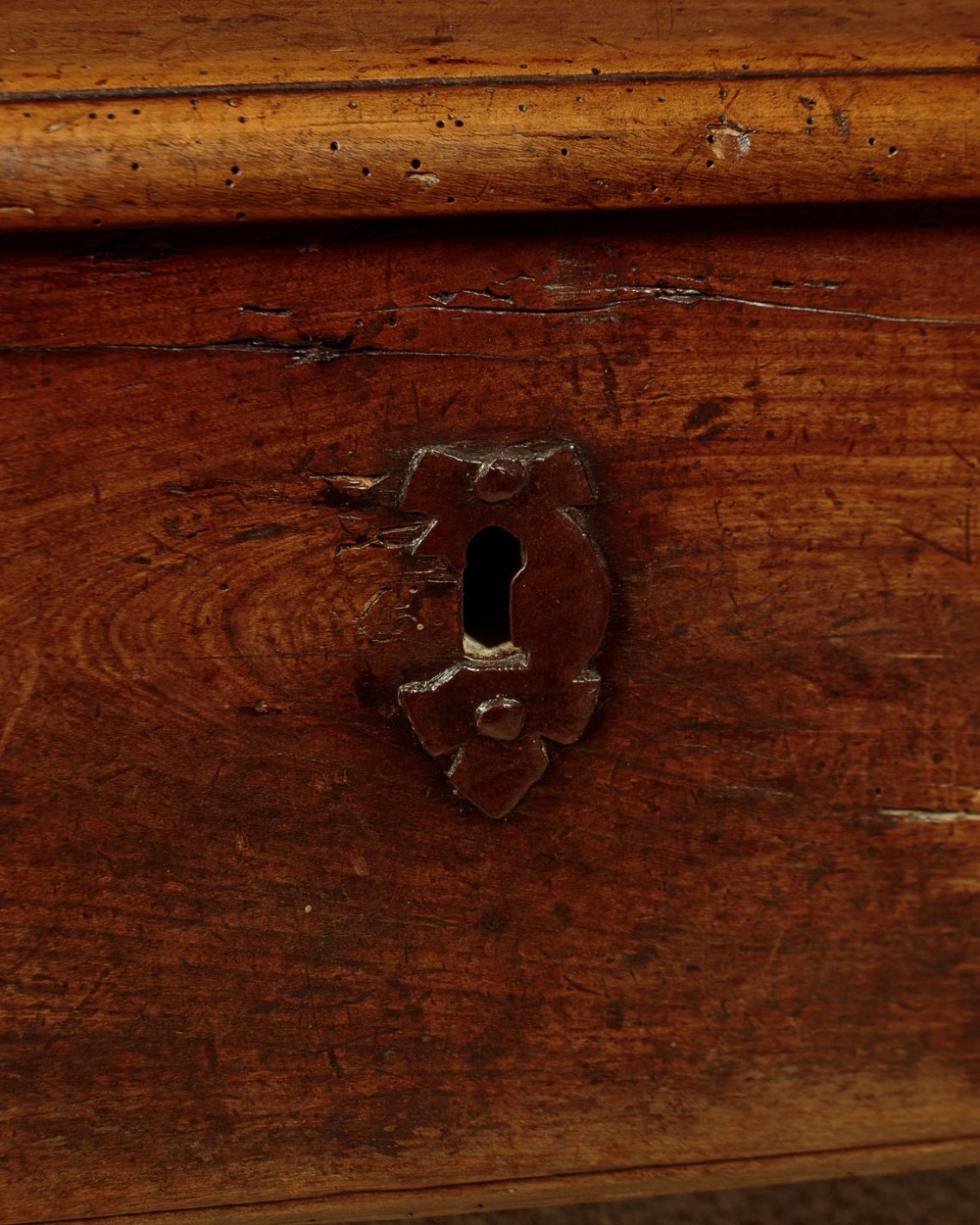 An eighteenth-century warm brown wooden box settle featuring turned end spindles, a hinged lid seat, and an iron keyhole escutcheon. View XIII