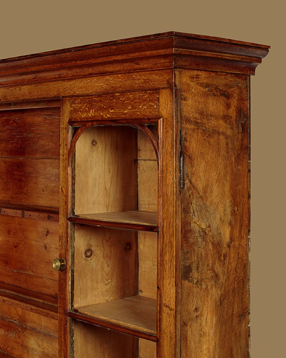 An antique nineteenth-century warm oak Welsh dog kennel dresser featuring an upper rack with glazed side cupboards above a three-drawer base with a central lower alcove. View VI