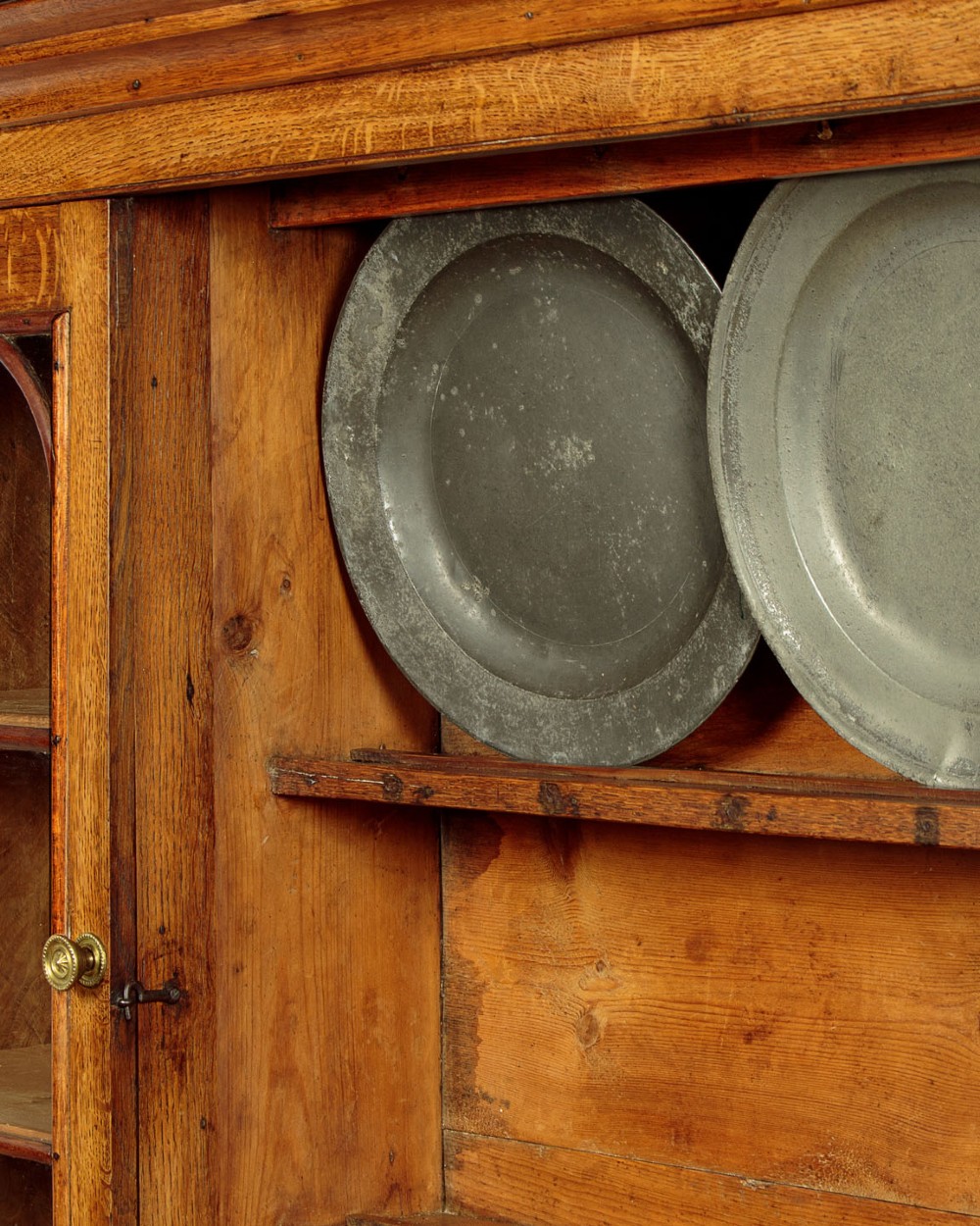 An antique nineteenth-century warm oak Welsh dog kennel dresser featuring an upper rack with glazed side cupboards above a three-drawer base with a central lower alcove. View IX