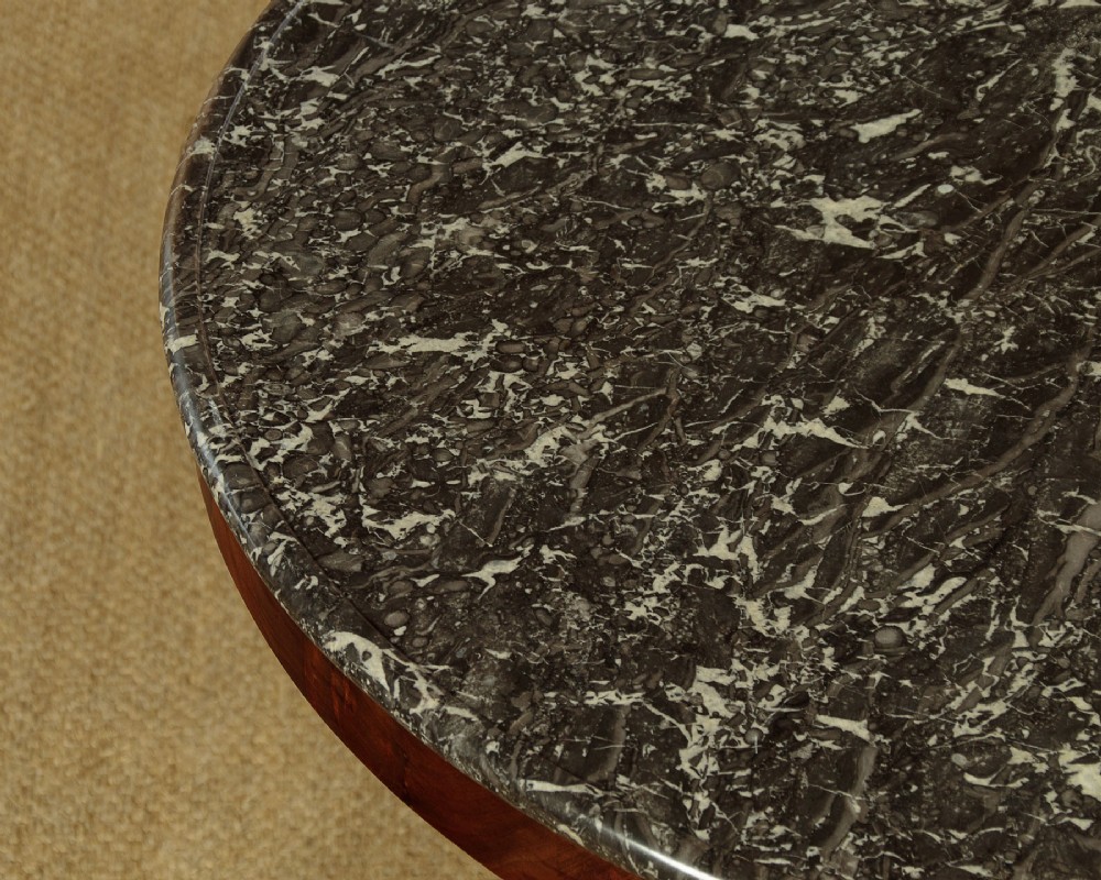 A circular antique mahogany gueridon centre table featuring a dark grey marble top, a flared central pedestal, and carved paw feet. View IV