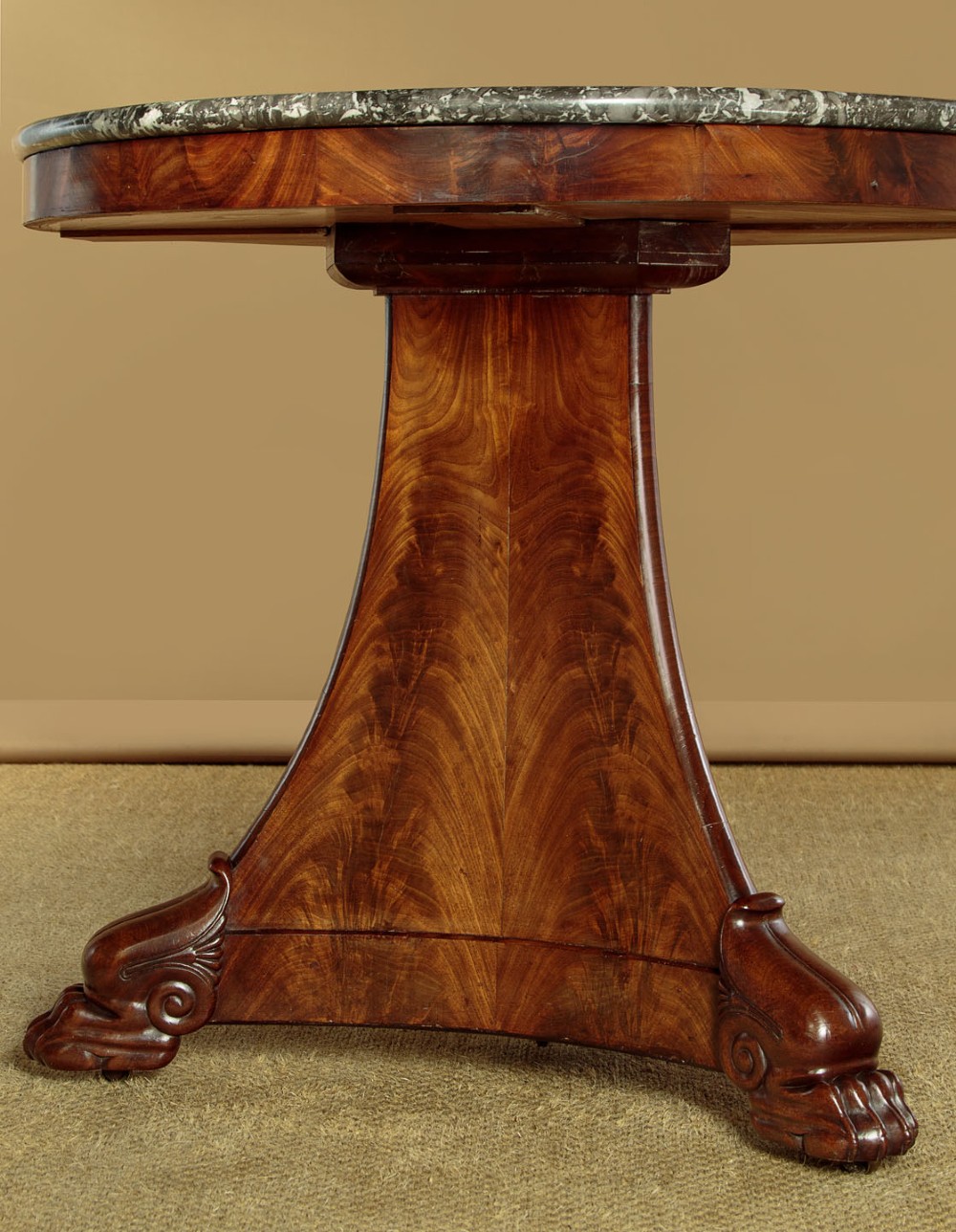 A circular antique mahogany gueridon centre table featuring a dark grey marble top, a flared central pedestal, and carved paw feet. View VI