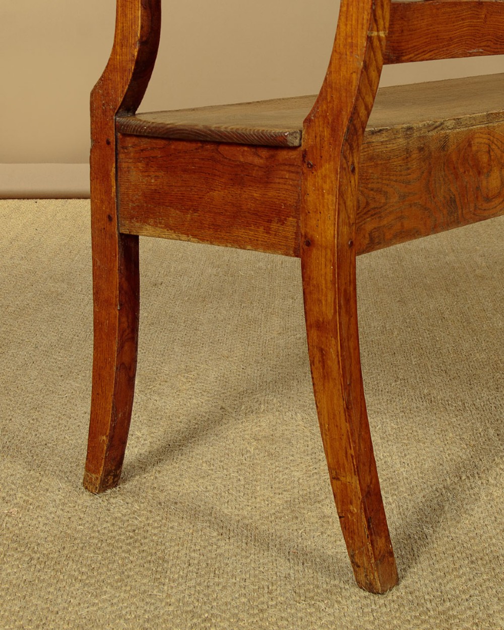 A nineteenth-century warm brown ash wooden hall bench featuring a backrest with seven pierced teardrop splats, scrolled armrests, and a solid plank seat. View IX